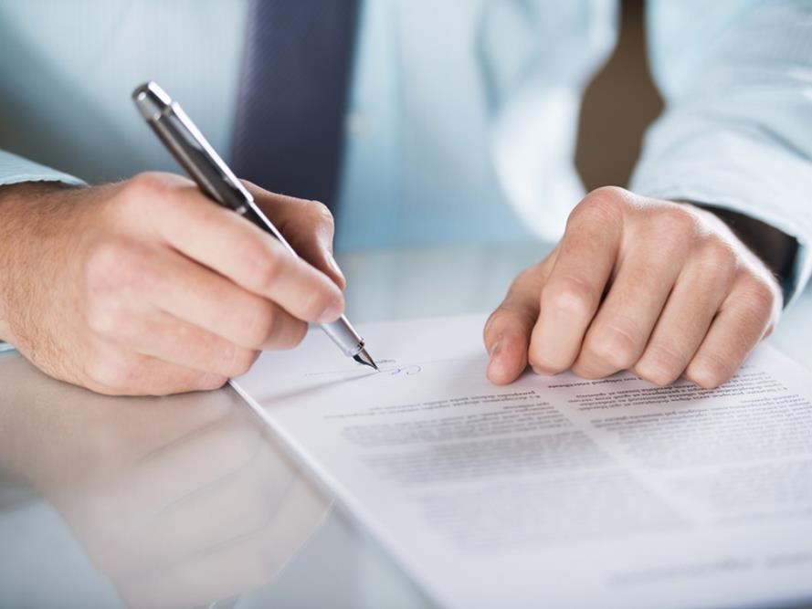 man signing legal documents 