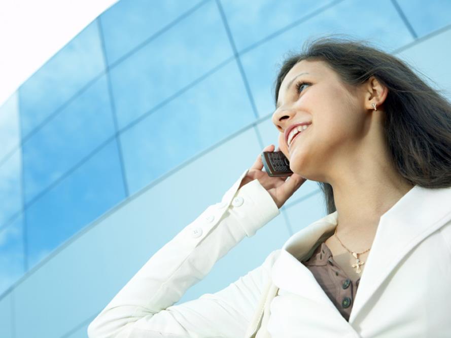 woman on phone outside of glass window building