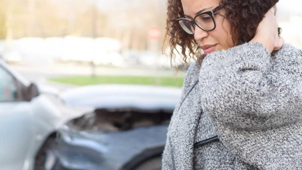 image of woman in front of car crash