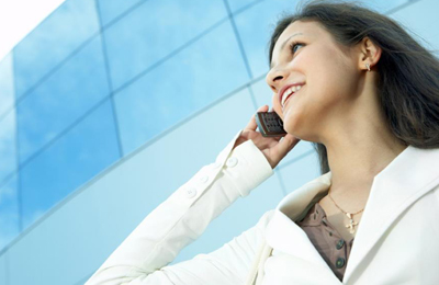 woman on phone outside of glass window building